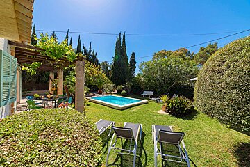 The backyard of a house with a swimming pool and chairs