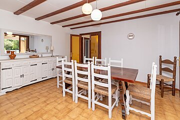 A dining room with a table and chairs and a mirror
