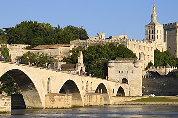A bridge over a river with a castle in the background
