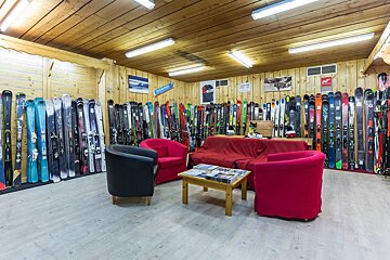 A room filled with lots of skis and a sign that says ' skis ' on it