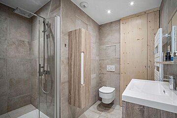 A bathroom with a toilet a sink and a shower