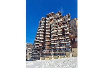 A large wooden building with many balconies and stairs