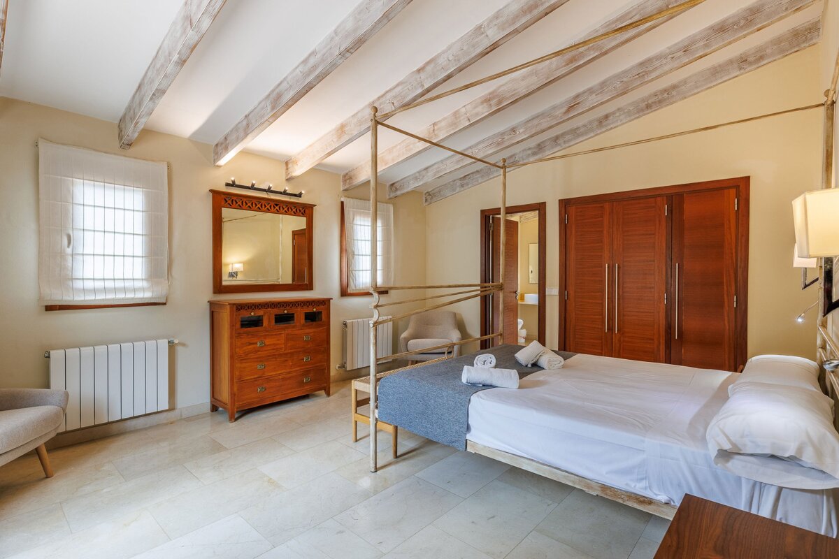 A bedroom with a canopy bed and a mirror