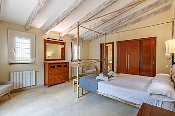 A bedroom with a canopy bed and a mirror