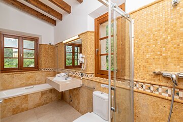 A bathroom with a toilet a sink and a window