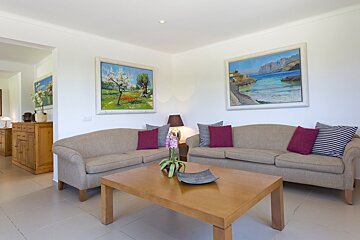 A living room with two couches and two paintings on the wall