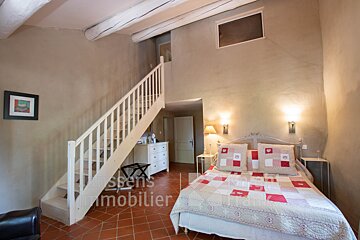 A bedroom with a bed and stairs and the word immobilier on the floor