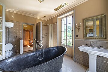 A bathroom with a black bathtub and a white sink