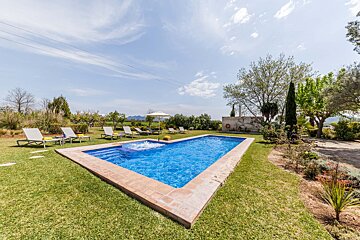 A large swimming pool surrounded by chairs and umbrellas