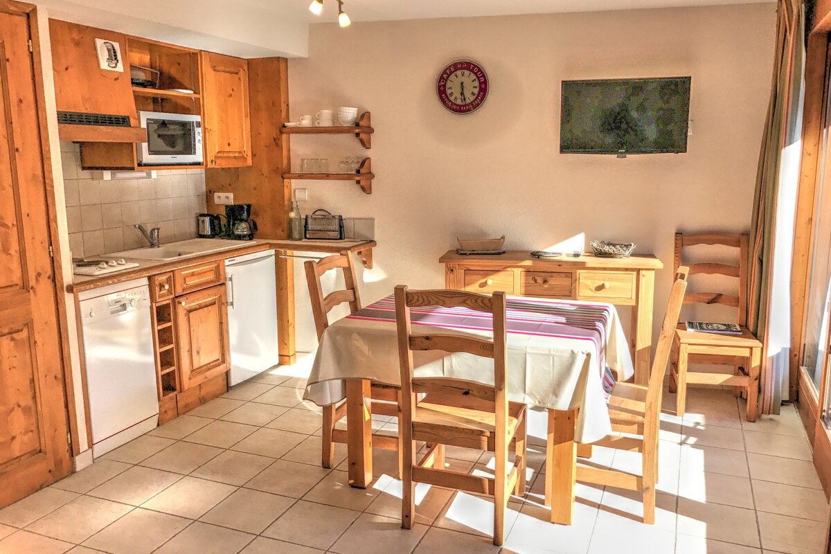 A kitchen with a table and chairs and a clock on the wall