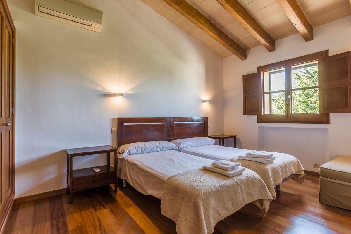 A bedroom with two twin beds and a window