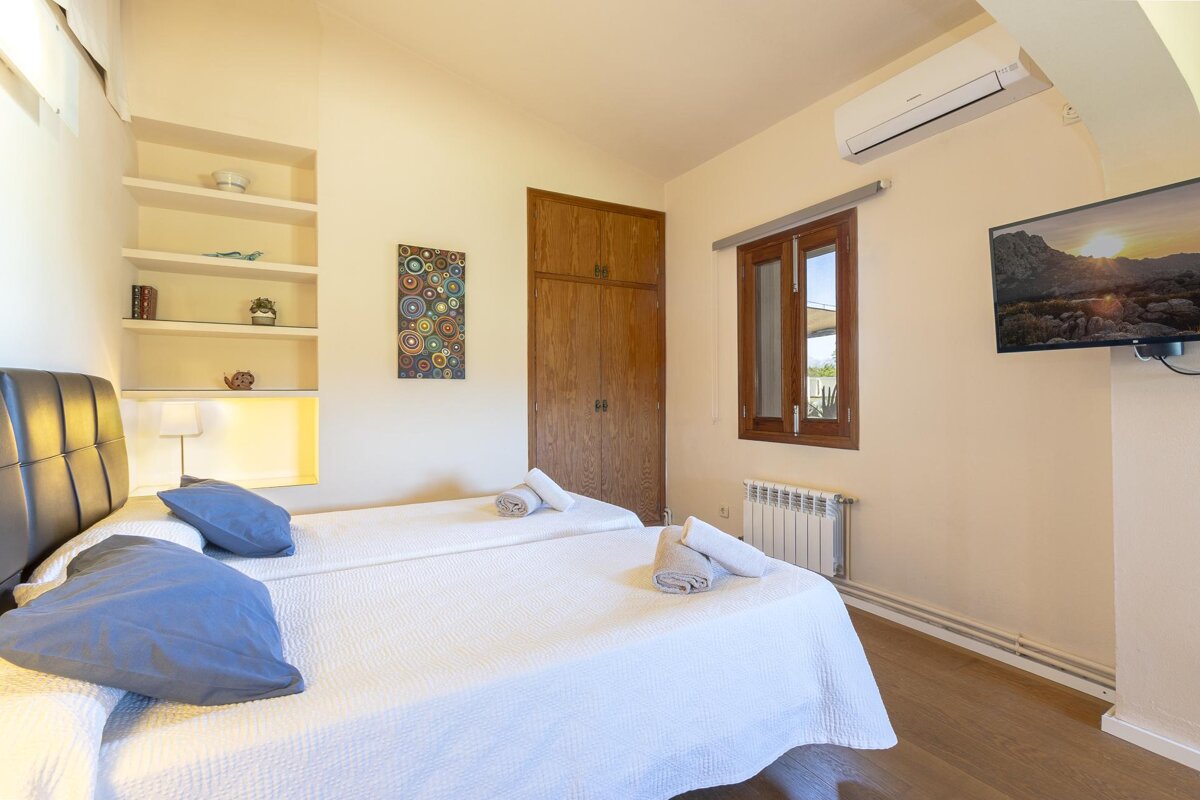 A bedroom with two beds and a flat screen tv