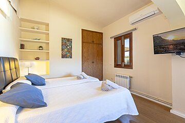 A bedroom with two beds and a flat screen tv