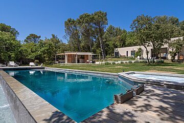 A large swimming pool with a house in the background
