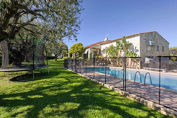 A house with a swimming pool and a trampoline in front of it