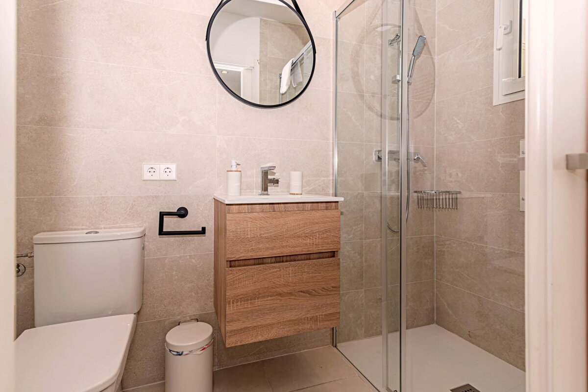 A bathroom with a toilet a sink and a mirror