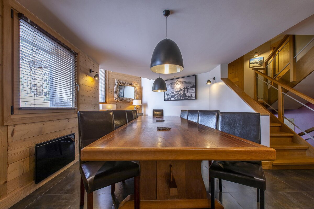 A dining room with a long wooden table and chairs