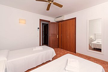 A bedroom with two beds and a ceiling fan