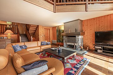 A living room with a table and chairs and a fireplace