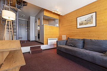 A living room with a couch and a picture on the wall