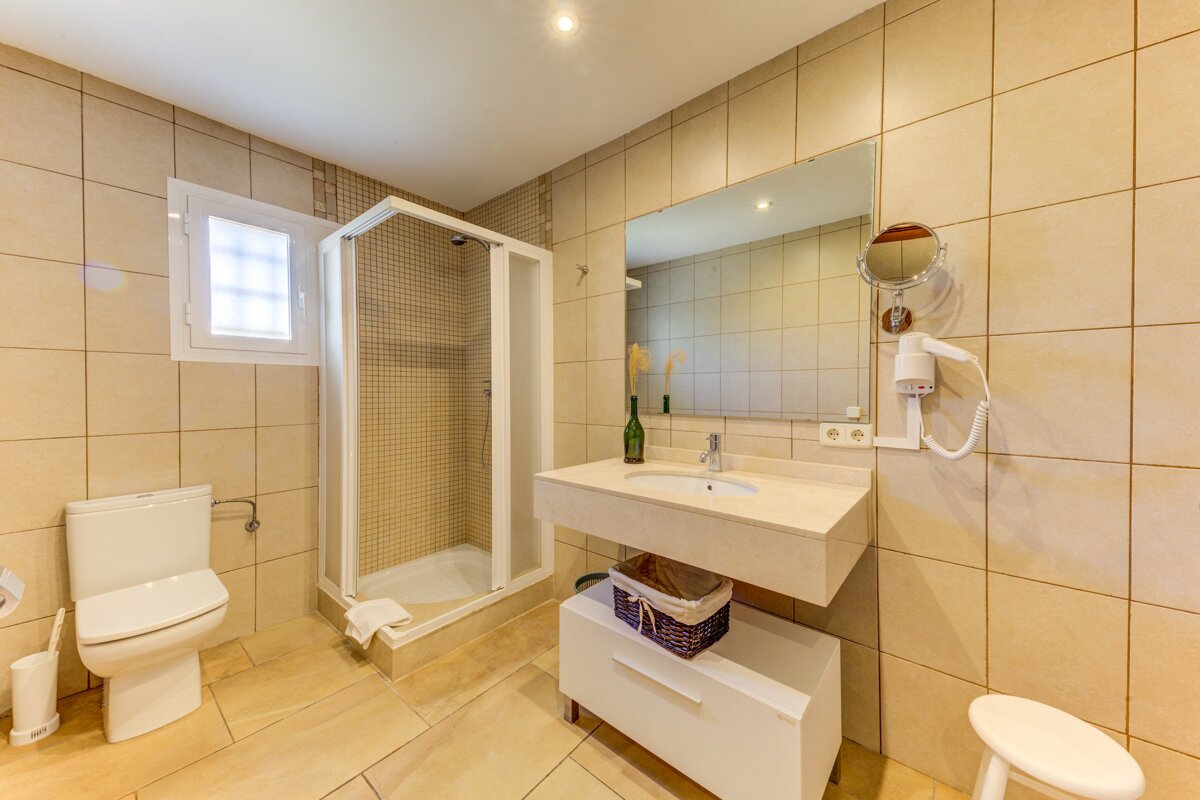 A bathroom with a toilet a sink and a mirror