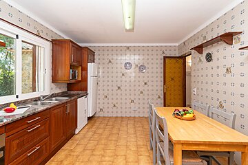 A kitchen with a table and chairs and plates on the wall