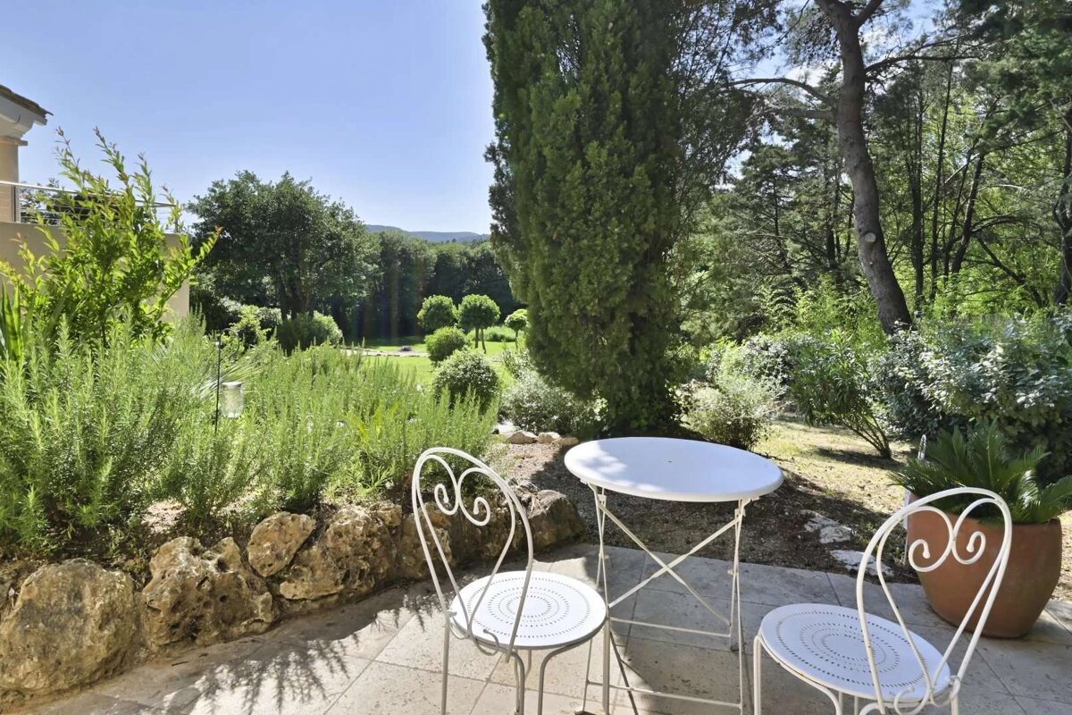 A patio with a table and chairs with the letter g on them