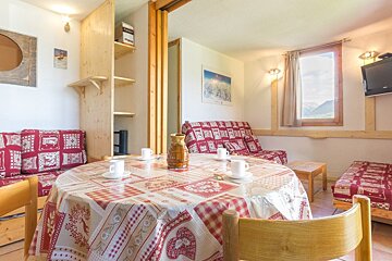 A table with a checkered table cloth and a pitcher on it
