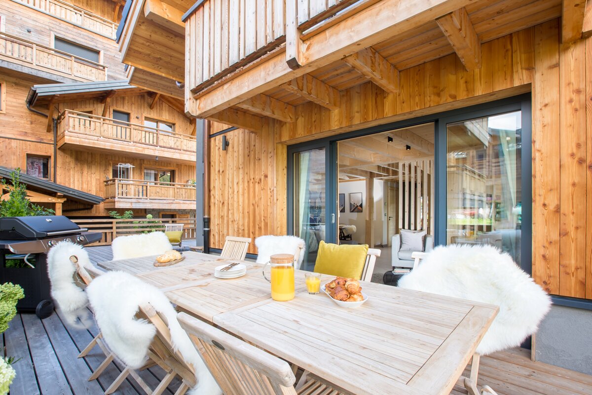 A wooden table with a pitcher of orange juice on it