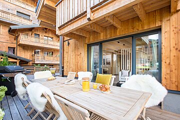 A wooden table with a pitcher of orange juice on it