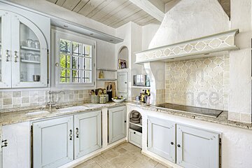 A kitchen with white cabinets and a stove top oven