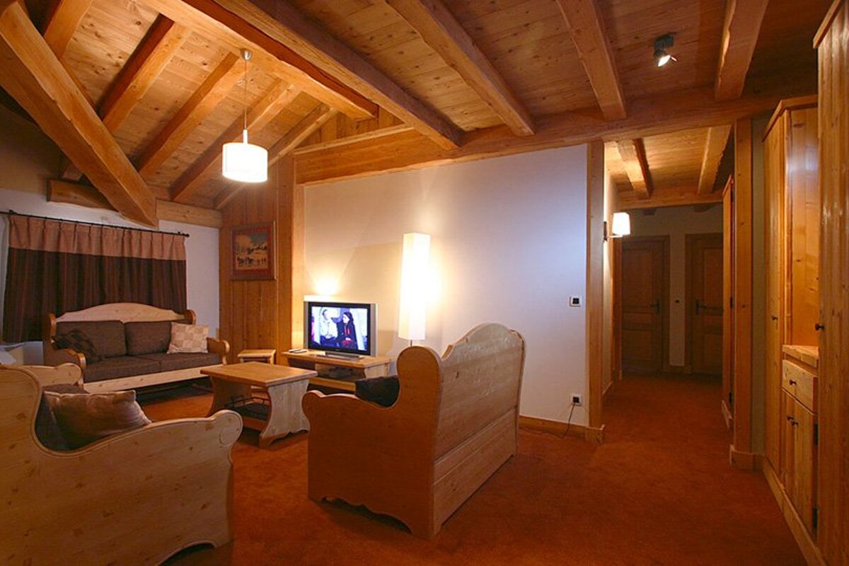 A living room with wooden furniture and a flat screen tv