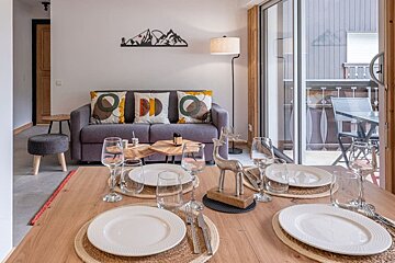 A living room with a couch and a table set for dinner