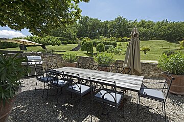 A patio with a table and chairs and umbrellas