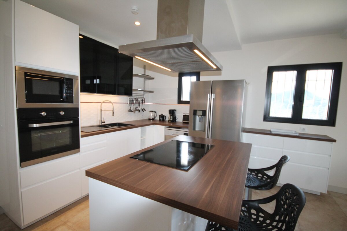A kitchen with a stove top oven and a stainless steel refrigerator
