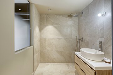 A bathroom with a sink and a walk in shower