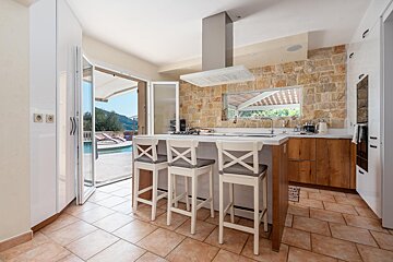 A kitchen with stools and a stove top oven