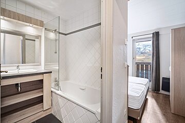 A bathroom with a bathtub a sink and a mirror