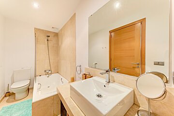 A bathroom with a sink toilet and mirror