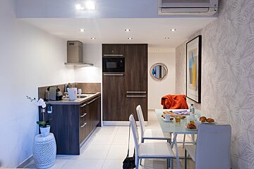A kitchen with a table and chairs and a picture on the wall