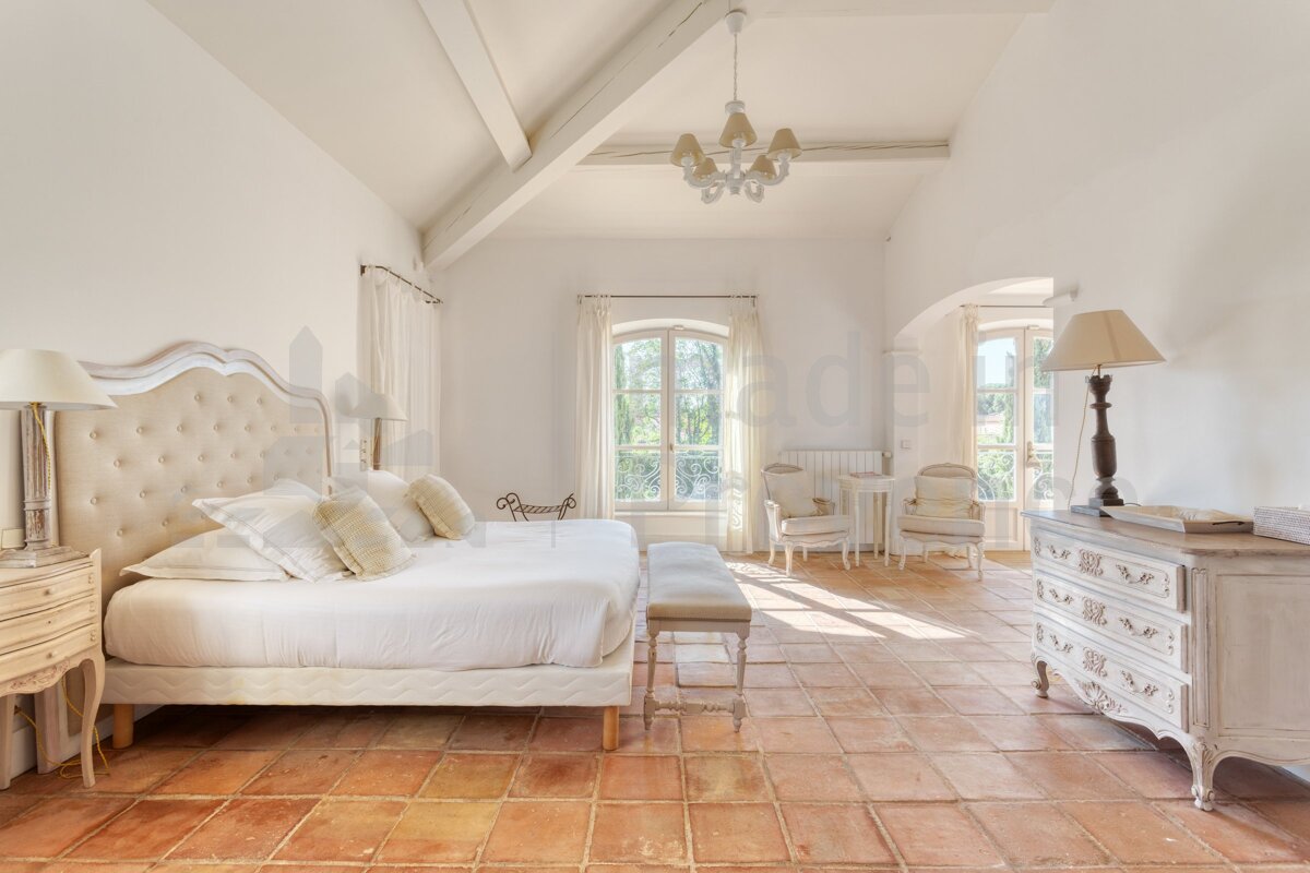 A bedroom with a large bed and a dresser