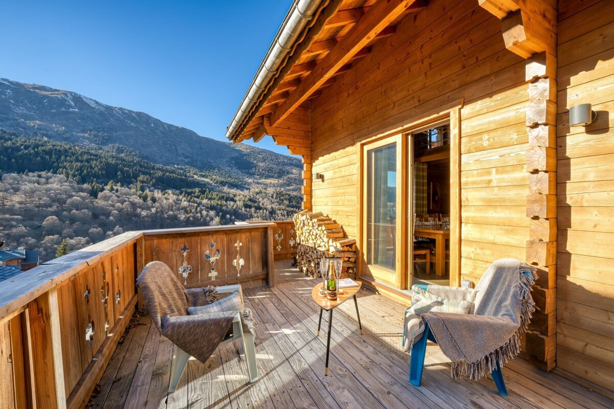A wooden balcony with a view of the mountains