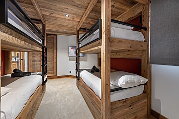 A room with bunk beds and a picture of a skier on the wall