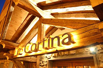 The word cortina that is on a wooden sign