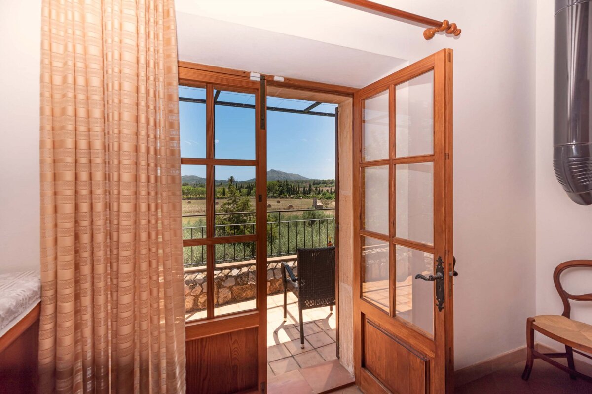 A door open to a balcony with mountains in the background