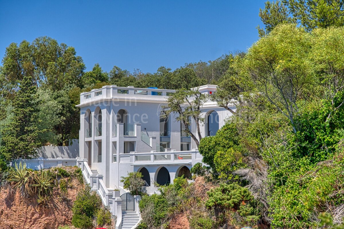 A large white house is surrounded by trees and says made in provence