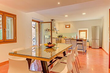 A dining room table with a bowl of fruit on it