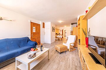 A living room with a blue couch and a white chair