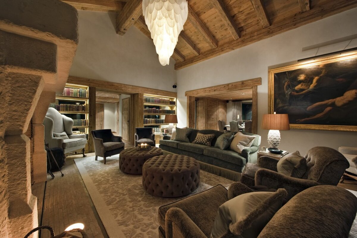 A living room with a couch chairs and ottomans