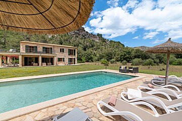 A large swimming pool with a house in the background